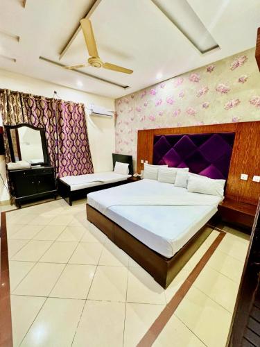 a bedroom with a large bed with a purple wall at Hotel PAK Continental Multan in Multan
