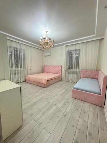 a large room with two beds and a chandelier at 2-комнатная по Караменде Би in Balqash