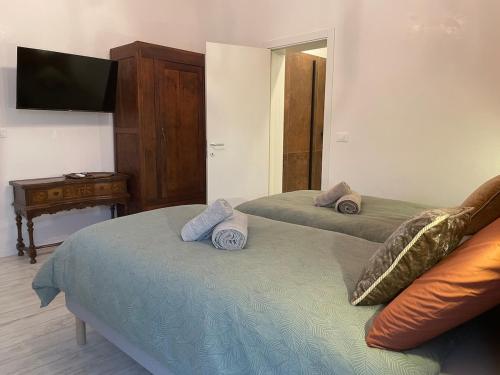 a bedroom with two beds and a tv on a wall at Casa Rossana - 15min from Venice in Mestre