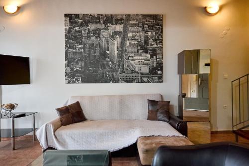 a living room with a couch and a painting on the wall at Μεζονέτα AIKATERINI N 8 in Chios