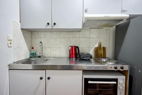 a small kitchen with a sink and a stove at Μεζονέτα AIKATERINI N 8 in Chios