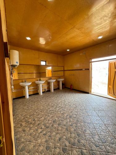 Un baño con cuatro lavabos en una habitación con ventana. en Qizilqum Safari Yurt Camp, en Narpay