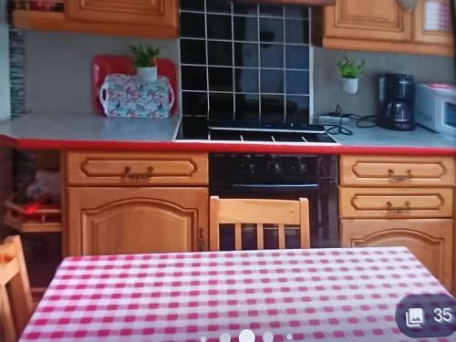 a kitchen with a table with a checkered table cloth at Chez Séverine gîtes in Marquise