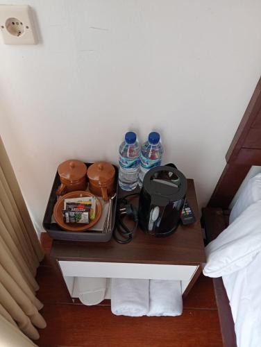 a tray with water bottles on a table next to a bed at Royal Indah Glamping Kintamani in Kintamani