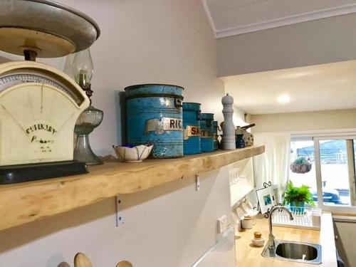 a kitchen counter with blue barrels on a shelf at Robin Hoods Well Farm Stay in Sassafras