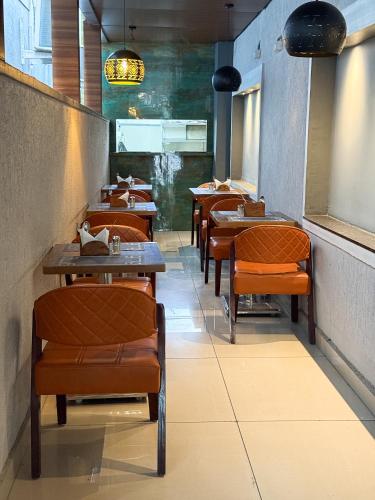 a row of tables and chairs in a restaurant at Hotel Landridge - HITECH City Hyderabad in Hyderabad