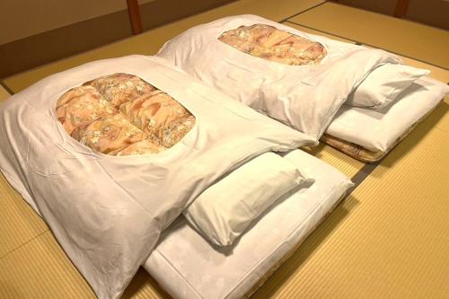 three pizzas in plastic bags on a table at TAKITEI Riverside Onsen ーA Hidden Ryokan in Kanazawaー in Kanazawa