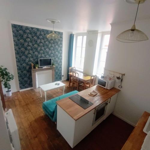 a living room with a table and a microwave at Le Clos doré Baie de Somme in Abbeville