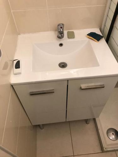 La salle de bains est pourvue d'un lavabo blanc et d'une douche. dans l'établissement Studio Meublé Toulouse, à Toulouse