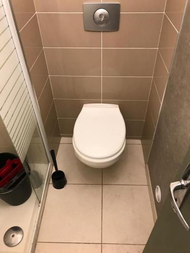 - une salle de bains avec des toilettes blanches dans une cabine dans l'établissement Studio Meublé Toulouse, à Toulouse