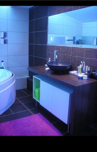 une salle de bain avec un lavabo et une baignoire dans l'établissement La maison de Stella, à Stella-Plage