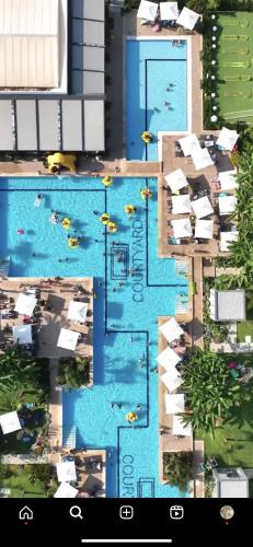 a screenshot of a pool with people in the water at Luxury studio room - in Courtyard Holiday Resort in İskele