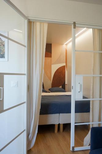 - une chambre avec un lit et une porte en verre dans l'établissement Le Soleil bleu Hyerois, à Hyères