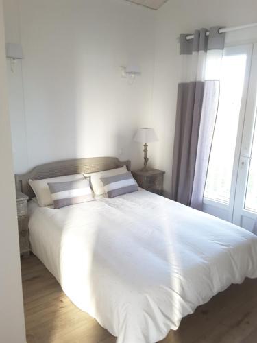 une chambre avec un grand lit blanc avec deux oreillers dans l'établissement Maison proche du Bassin d'Arcachon, à Salles