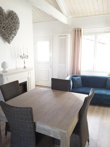 - un salon avec une table en bois et un canapé bleu dans l'établissement Maison proche du Bassin d'Arcachon, à Salles