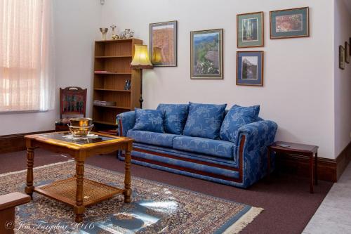 a living room with a blue couch and a table at Aarn House B&B Airport Accommodation in Perth