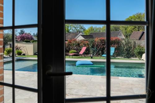 - une fenêtre offrant une vue sur la piscine dans l'établissement Villa Tharonnaise-10min parc fédéral CAUTION OBLIGATOIRE, à Chaumont-sur-Tharonne