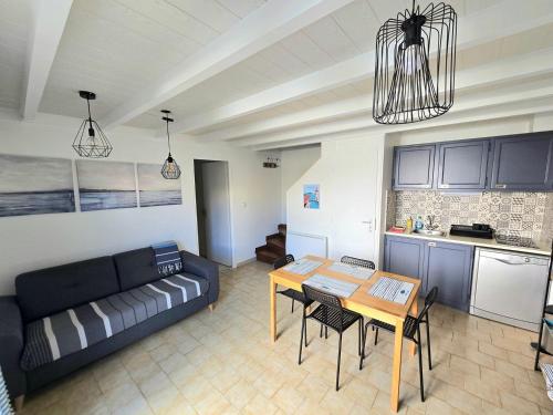 un salon avec un canapé et une table dans l'établissement SANTOLINES : Charmante maisonnette avec piscine proche Etang, à Marseillan