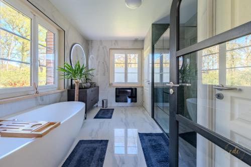 une salle de bain avec baignoire et douche en verre dans l'établissement Villa Tharonnaise-10min parc fédéral CAUTION OBLIGATOIRE, à Chaumont-sur-Tharonne