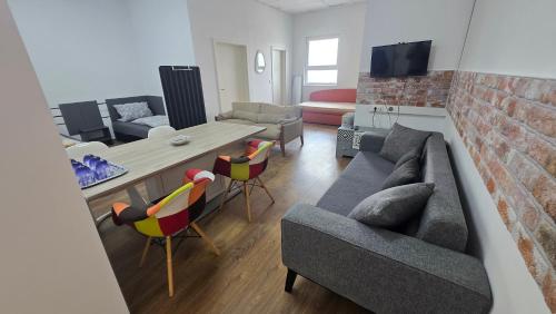 a living room with a couch and a table and chairs at Work & Family Apartment Herzogenaurach in Herzogenaurach