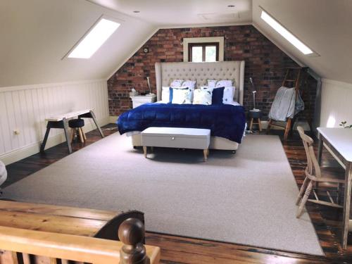 a bedroom with a bed and a brick wall at Robin Hoods Well Farm Stay in Sassafras