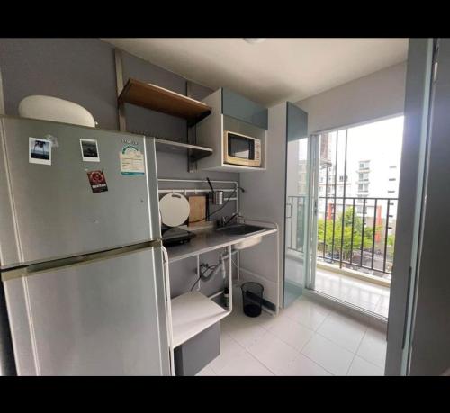a small kitchen with a refrigerator and a window at D Condo phuket kathu- patong in Amphoe Kathu