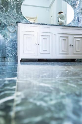 une salle de bain avec un lavabo, un miroir et de l'eau dans l'établissement Le Clos Cathala Chambres d'Hôtes, à Saint-Paul-de-Jarrat
