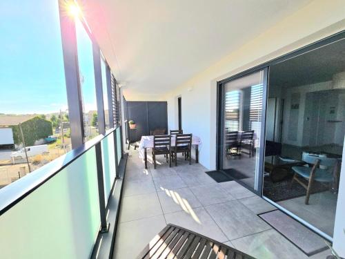 - un balcon avec vue sur une table et des chaises dans l'établissement MILLESIME 5202 : Belle vue proche du port, élégant avec parking, à Marseillan