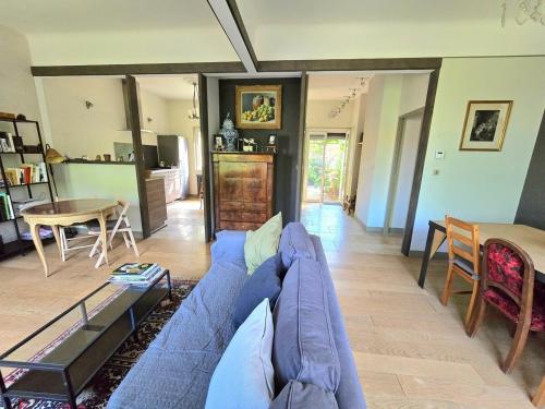 un salon avec un canapé bleu et une table dans l'établissement COTTAGE : Charmante maison et jardin arboré en ville, à Montpellier