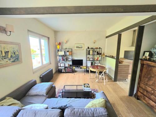 un salon avec un canapé et une table dans l'établissement COTTAGE : Charmante maison et jardin arboré en ville, à Montpellier