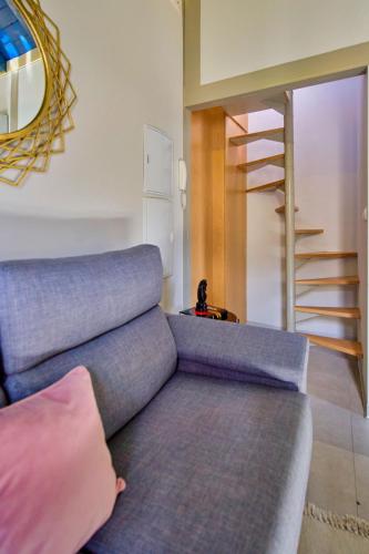 a living room with a couch and a staircase at Zirí Suites - Hostatel in Granada