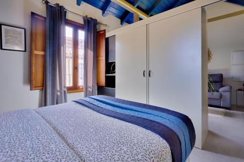 a bedroom with a bed and a white cabinet at Zirí Suites - Hostatel in Granada
