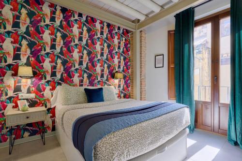 a bedroom with a bed and a colorful wall at Zirí Suites - Hostatel in Granada
