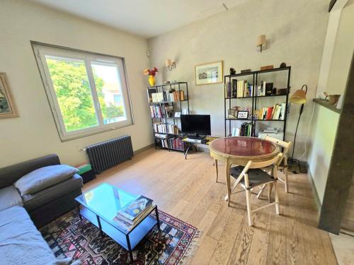 un salon avec un canapé et une table dans l'établissement COTTAGE : Charmante maison et jardin arboré en ville, à Montpellier