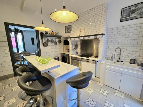 - une cuisine avec un comptoir et des tabourets dans l'établissement CARNOT : Charmante maison Vigneronne en centre historique, à Agde