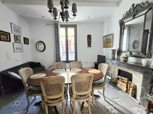une salle à manger avec une table et des chaises et une cheminée dans l'établissement CARNOT : Charmante maison Vigneronne en centre historique, à Agde