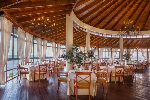 a banquet hall with tables and chairs and windows at Eurostars Grand Cayacoa in Santa Bárbara de Samaná