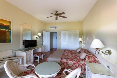 a bedroom with a bed and a table and chairs at Eurostars Grand Cayacoa in Santa Bárbara de Samaná
