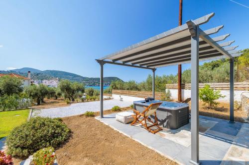 a pergola with a grill in a yard at Marani Home & Villas in Skopelos Town