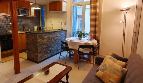 Il dispose d'une cuisine et d'un salon avec une table et un canapé. dans l'établissement Logement très confortable et bien situé à Cannes, à Cannes