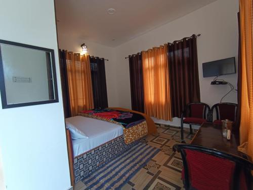 1 dormitorio pequeño con 1 cama, mesa y sillas en NamahStay Dhanaulti, en Dhanaulti