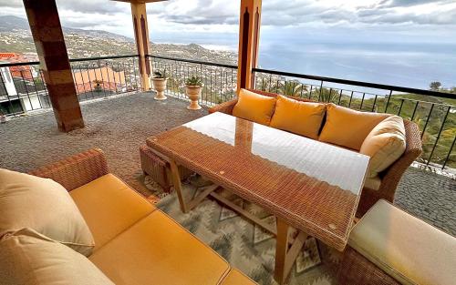 a patio with a table and chairs on a balcony at Villa Michelangelo in Câmara de Lobos