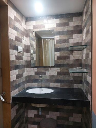 a bathroom with a sink and a mirror at Hotel Shiv Parvati International, Solapur in Solapur