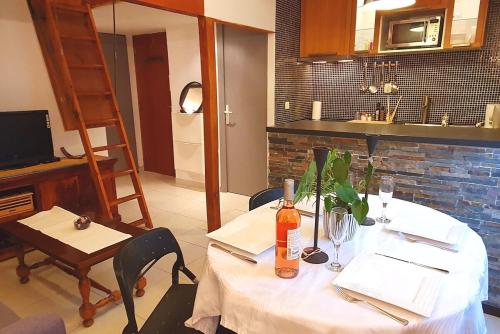 - une table avec un chiffon de table blanc et une bouteille de vin dans l'établissement Logement très confortable et bien situé à Cannes, à Cannes
