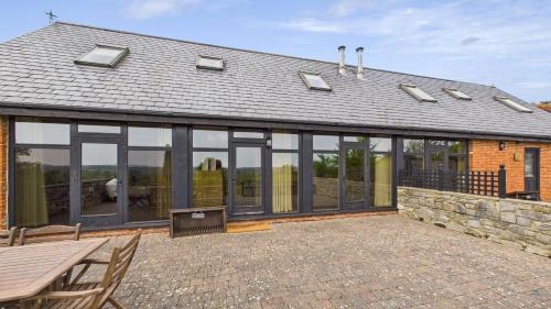 a house with large glass windows on a patio at Tithe Barn a Stunning family home with panoramic views in Ryde