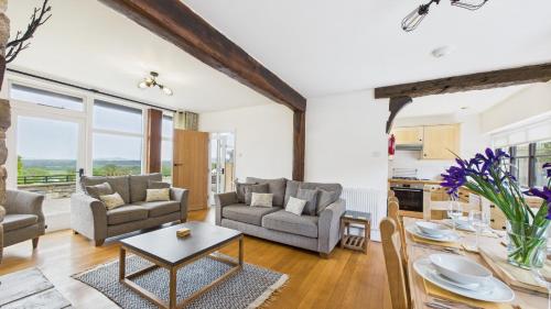 a living room with couches and a table at Tithe Barn a Stunning family home with panoramic views in Ryde