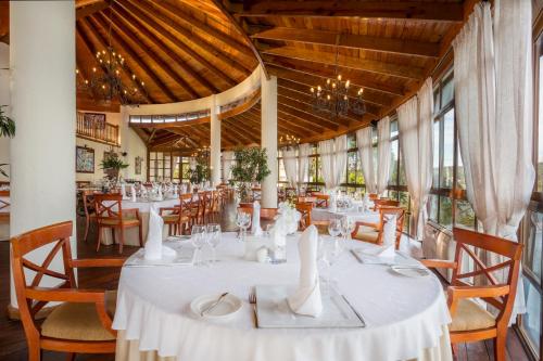 a dining room with white tables and chairs at Eurostars Grand Cayacoa in Santa Bárbara de Samaná