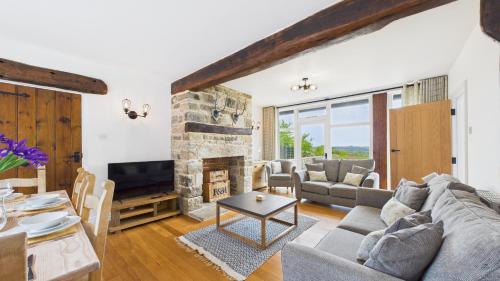 a living room with a couch and a fireplace at Tithe Barn a Stunning family home with panoramic views in Ryde