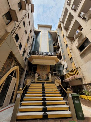 a group of people walking up the stairs of a building at Hotel Shiv Parvati International, Solapur in Solapur