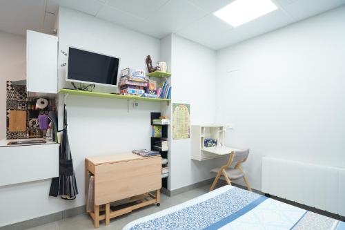 Pokój z biurkiem i telewizorem na ścianie w obiekcie Aldabea II apartamento sostenible w mieście Legazpia